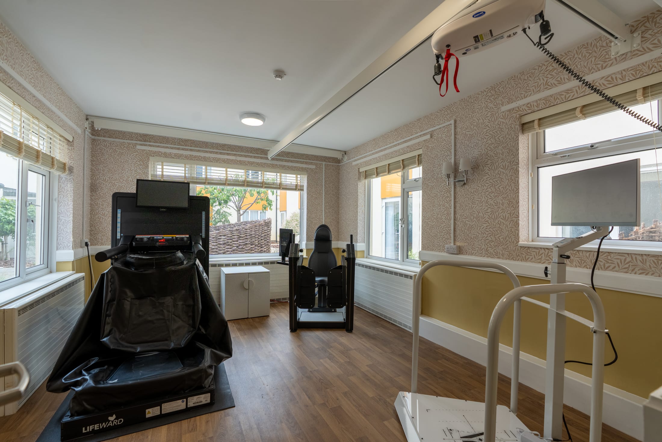 Rehabilitation gym at California House, with specialist equipment and a ceiling hoist